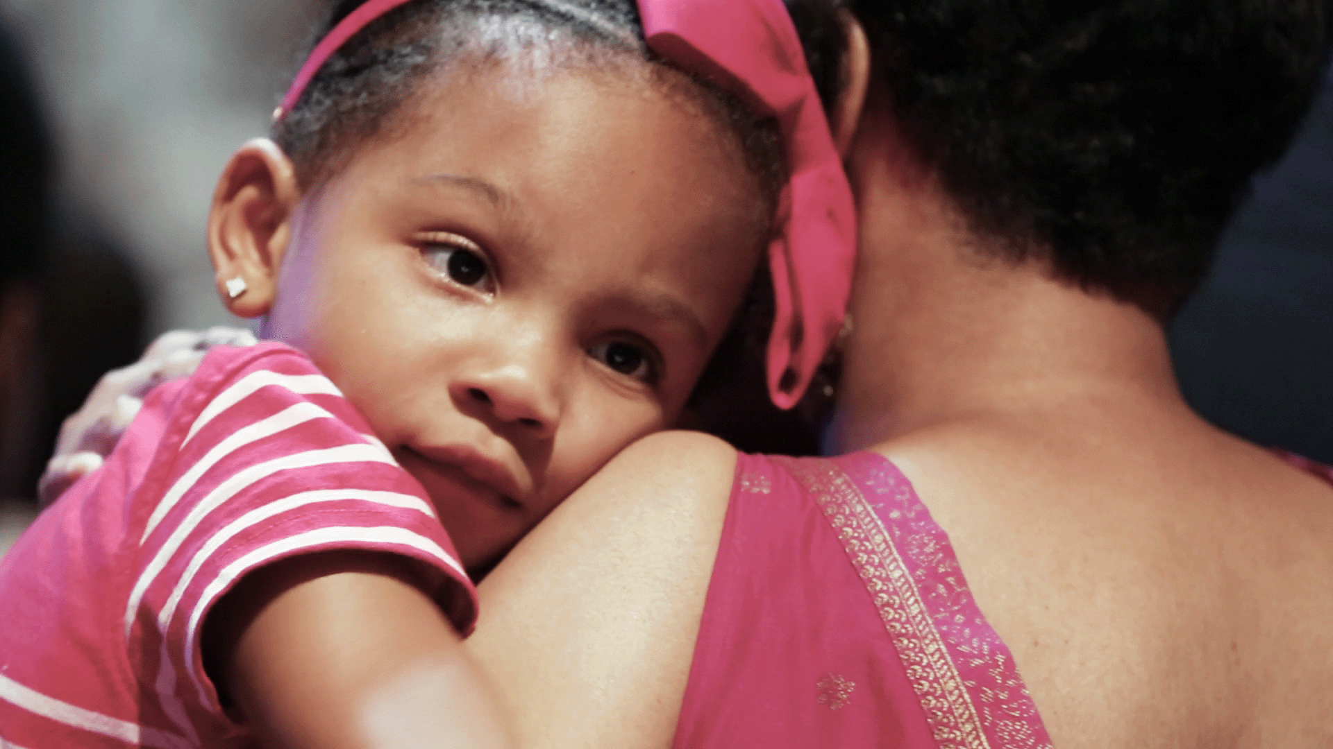 little girl looking over the shoulder of an adult female